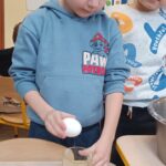 Dzieci robią faworki.