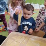 Dzieci robią faworki.