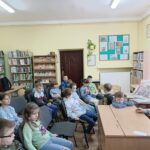 Dziewczęta czytają młodszym kolegom.