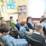 Dziewczęta czytają młodszym kolegom.