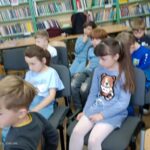 Dziewczęta czytają młodszym kolegom.