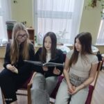 Dziewczęta czytają młodszym kolegom.