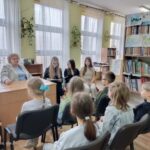 Dziewczęta czytają młodszym kolegom.