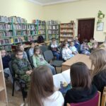 Dziewczęta czytają młodszym kolegom.