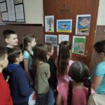 Dziewczęta czytają młodszym kolegom.