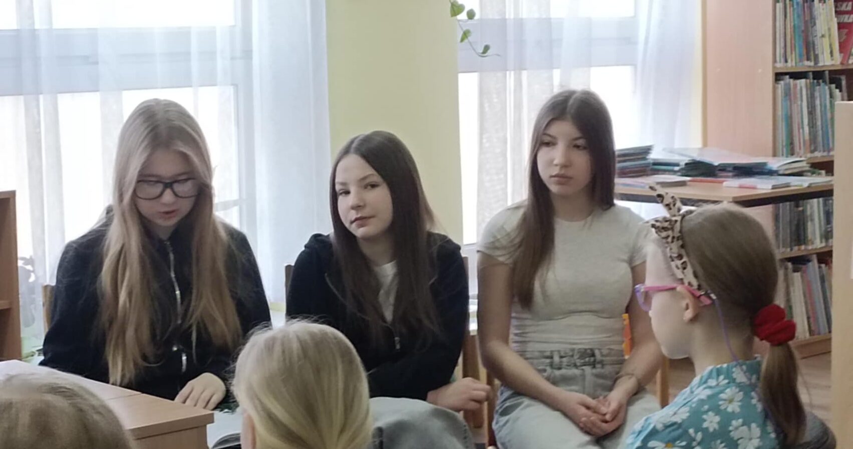 Dziewczęta czytają młodszym kolegom.