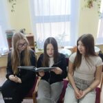 Dziewczęta czytają młodszym kolegom.