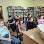 Dziewczęta czytają młodszym kolegom.