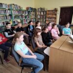 Dziewczęta czytają młodszym kolegom.