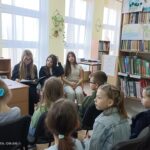 Dziewczęta czytają młodszym kolegom.