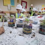 Uczniowie projektują mini ogród w słoiku.